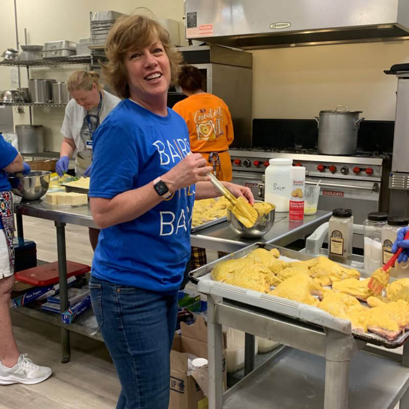 A volunteer lays out taco shells on a tray