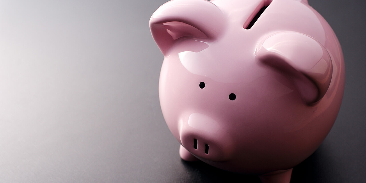 Angled photo of a simple, pink, ceramic piggy bank.