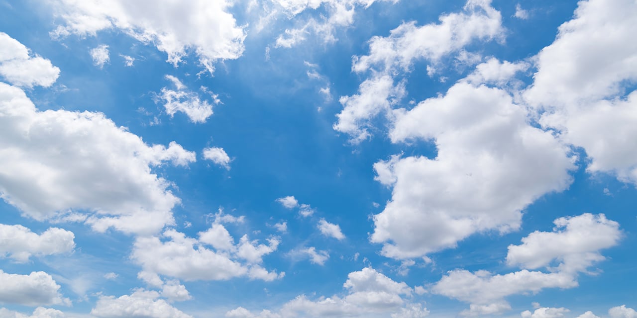 Blue sky with scattered white clouds.