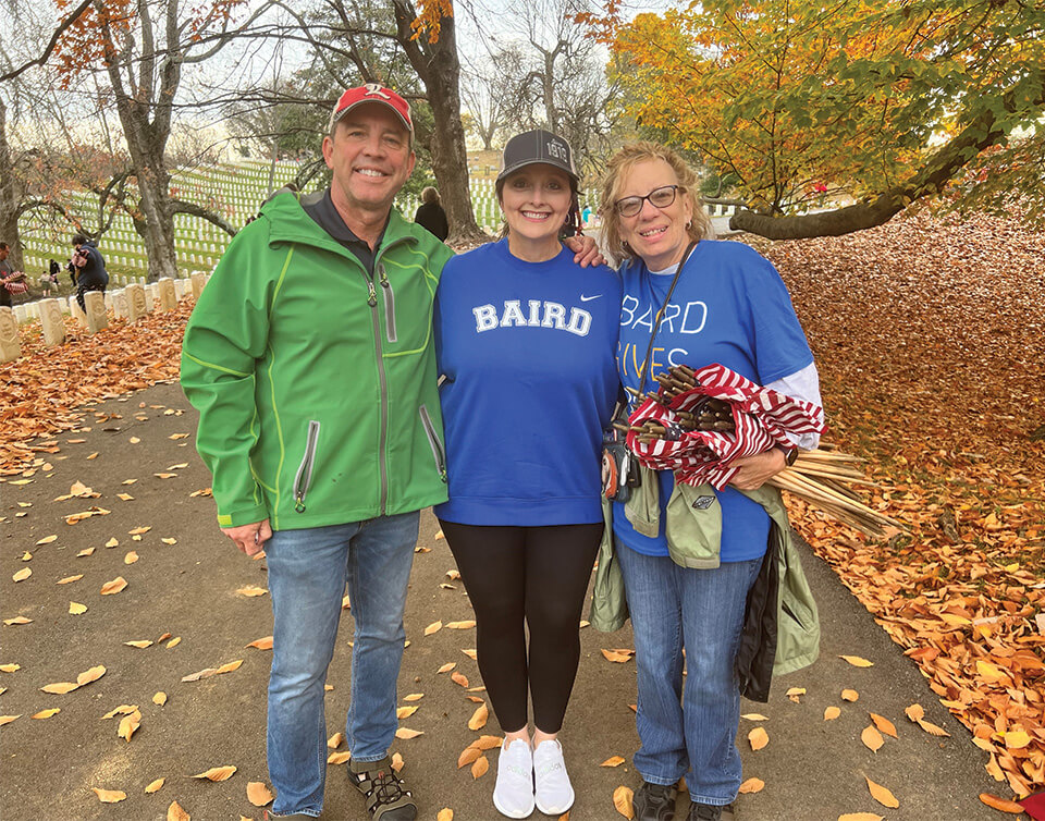 Baird Trust associates place flags in Cave Hill Cemetary