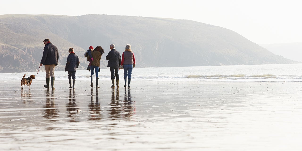 Multi-generational family walking on the beach
