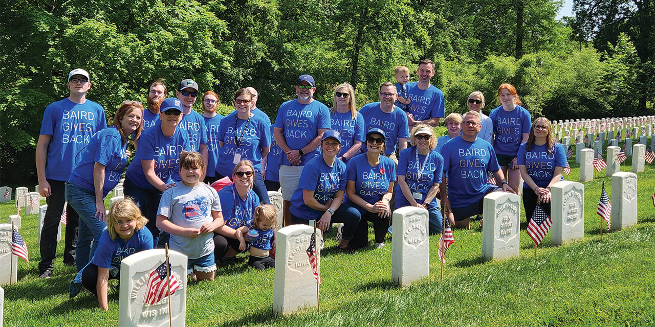 A group of Baird Trust associates wearing Baird Gives Back t-shirts in Cave Hill cemetery