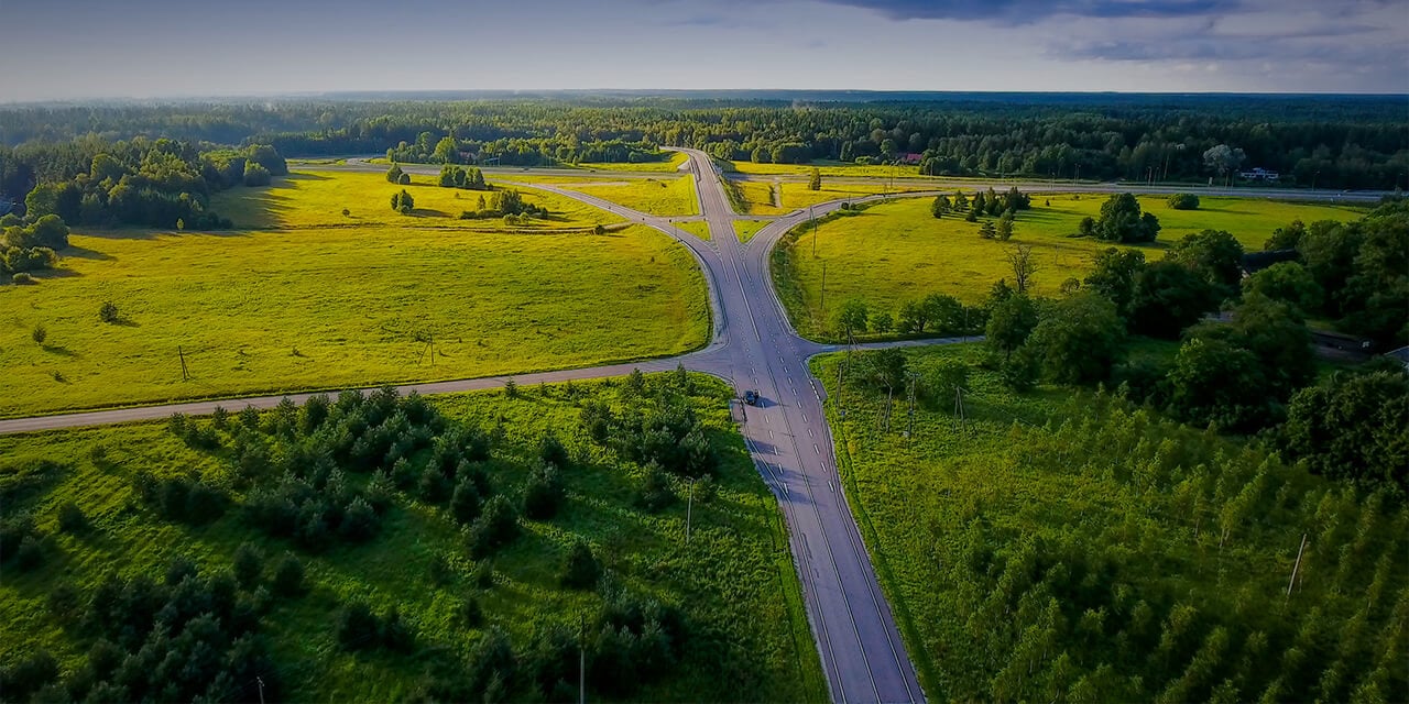 Aerial shot of a road branching off into five directions as it extends into the horizon